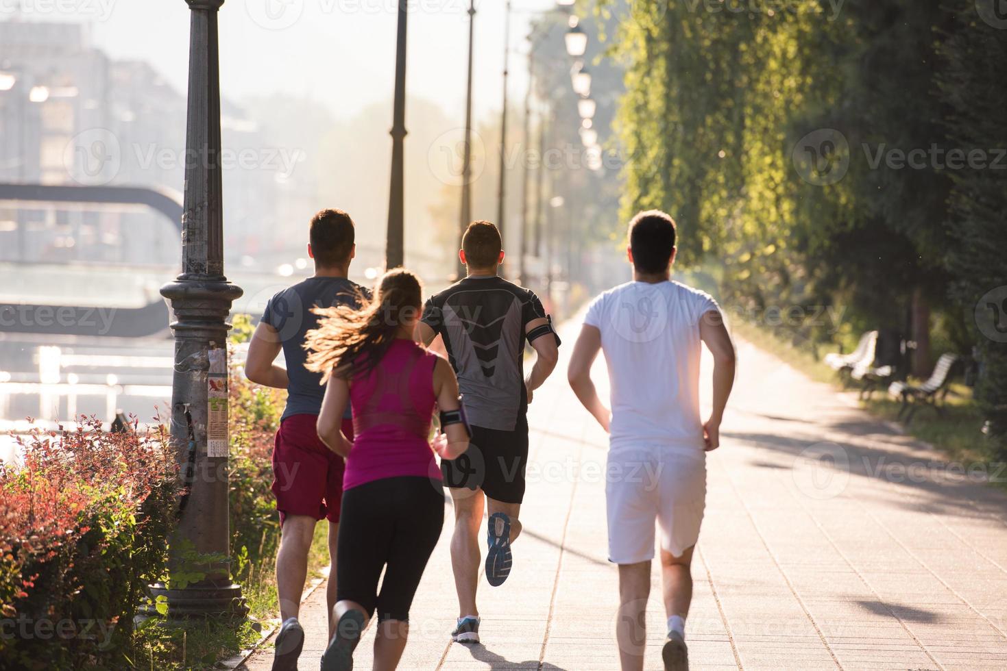 gruppo di giovani che fanno jogging in città foto