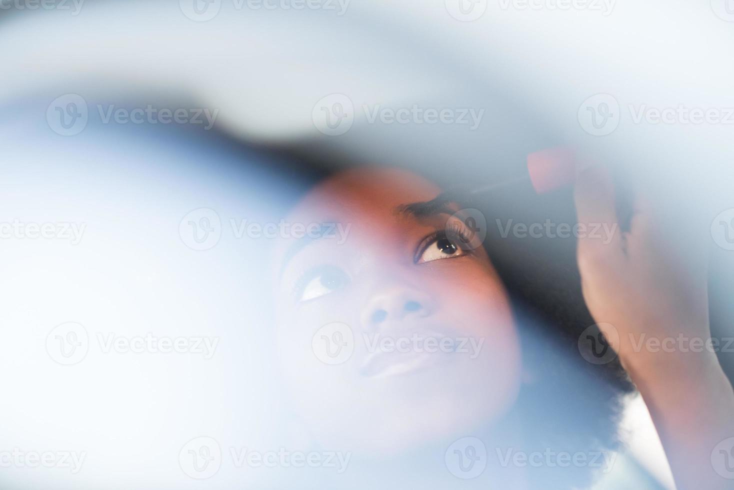 donna che fa il trucco mentre guida l'auto foto