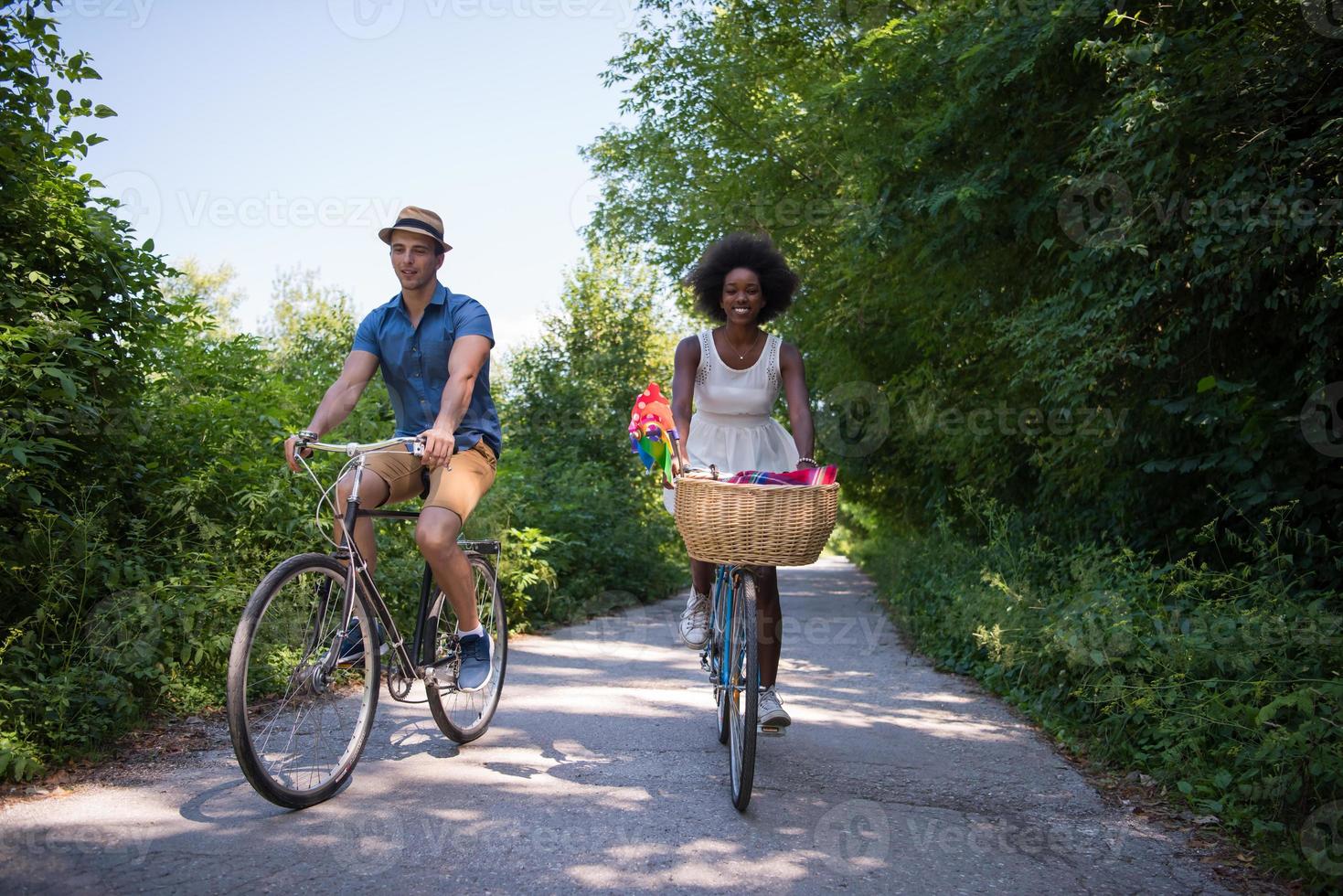 giovane coppia multietnica che fa un giro in bicicletta nella natura foto