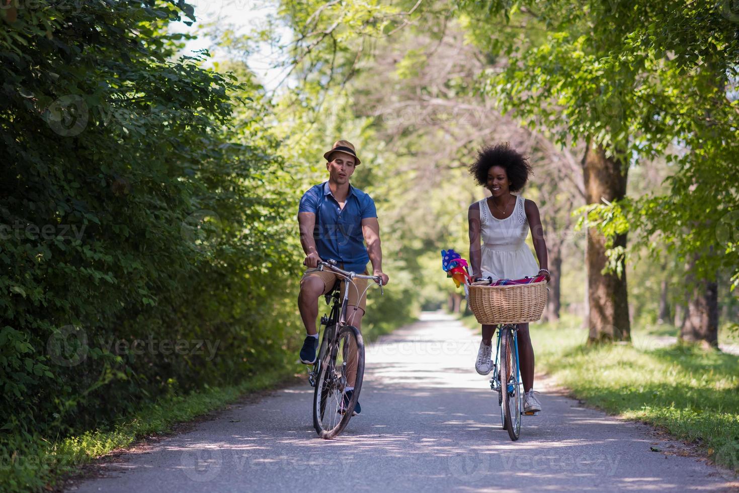 giovane coppia multietnica che fa un giro in bicicletta nella natura foto