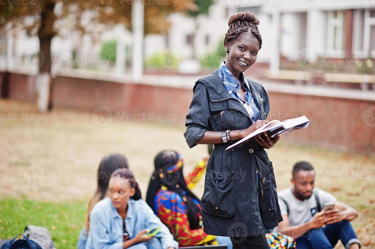 gruppo di cinque studenti universitari africani che trascorrono del tempo insieme nel campus nel cortile dell'università. amici afro neri che studiano. tema dell'educazione. foto