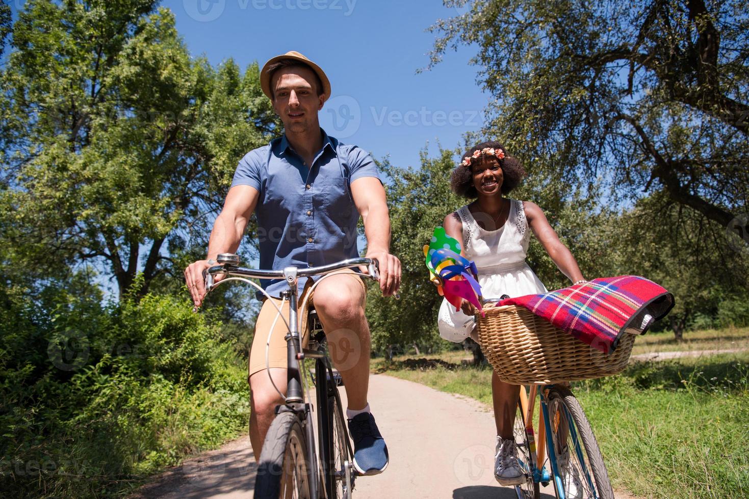 giovane coppia multietnica che fa un giro in bicicletta nella natura foto