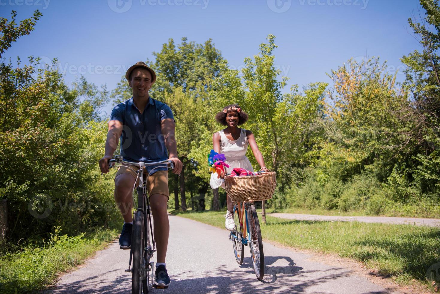 giovane coppia multietnica che fa un giro in bicicletta nella natura foto