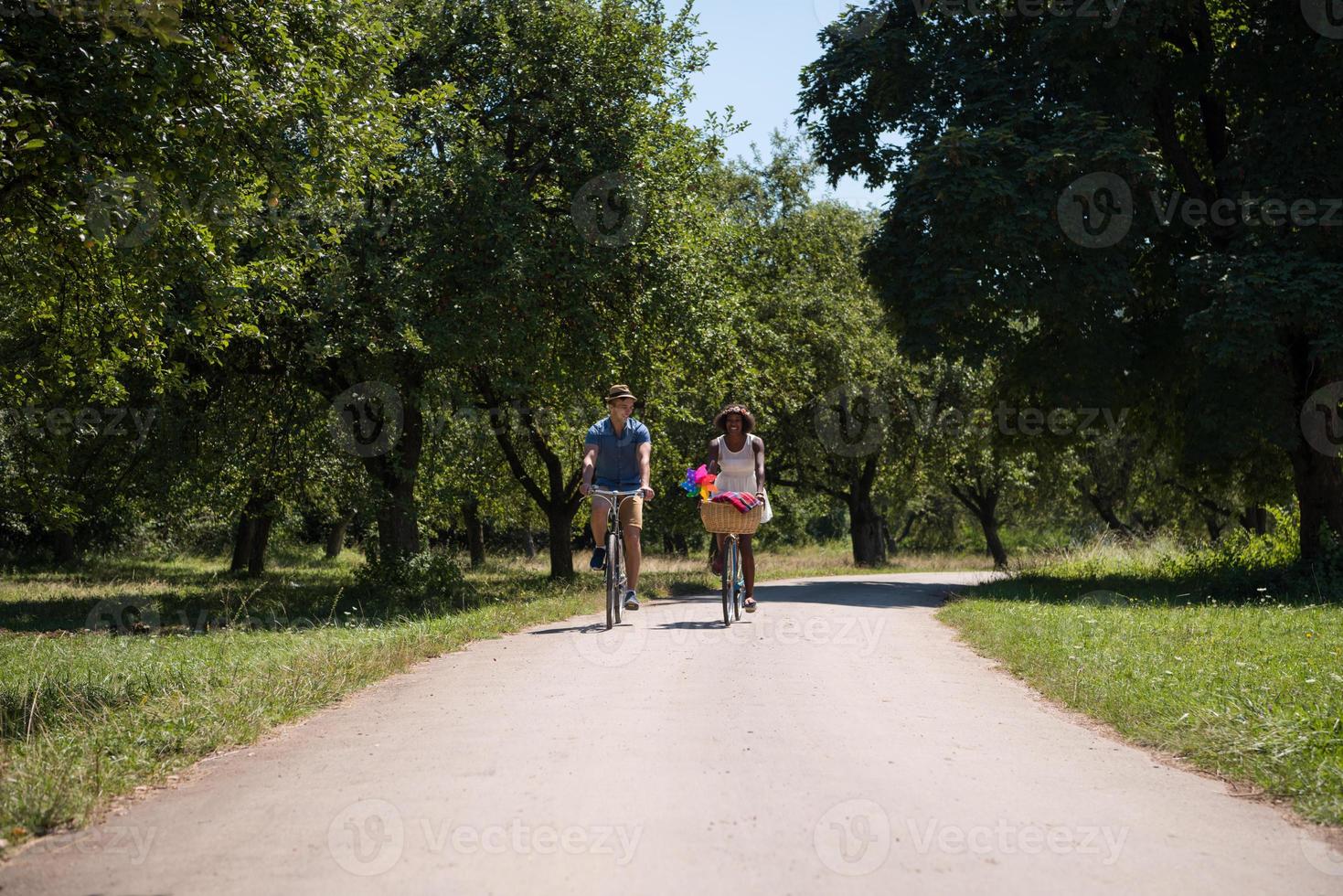 giovane coppia multietnica che fa un giro in bicicletta nella natura foto