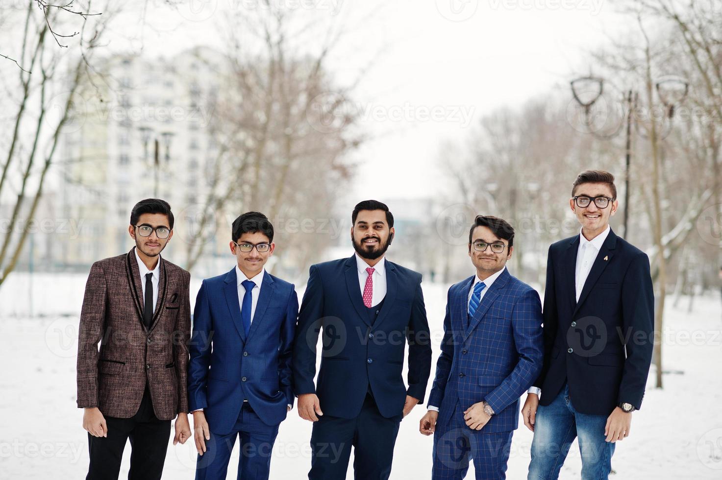 un gruppo di cinque uomini d'affari indiani in giacca e cravatta poste all'aperto in una giornata invernale in Europa. foto