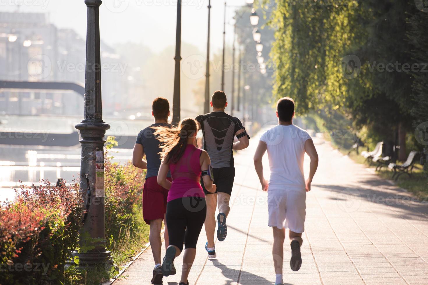 gruppo di giovani che fanno jogging in città foto