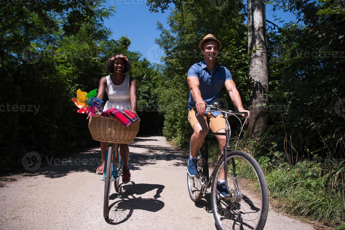 giovane coppia multietnica che fa un giro in bicicletta nella natura foto