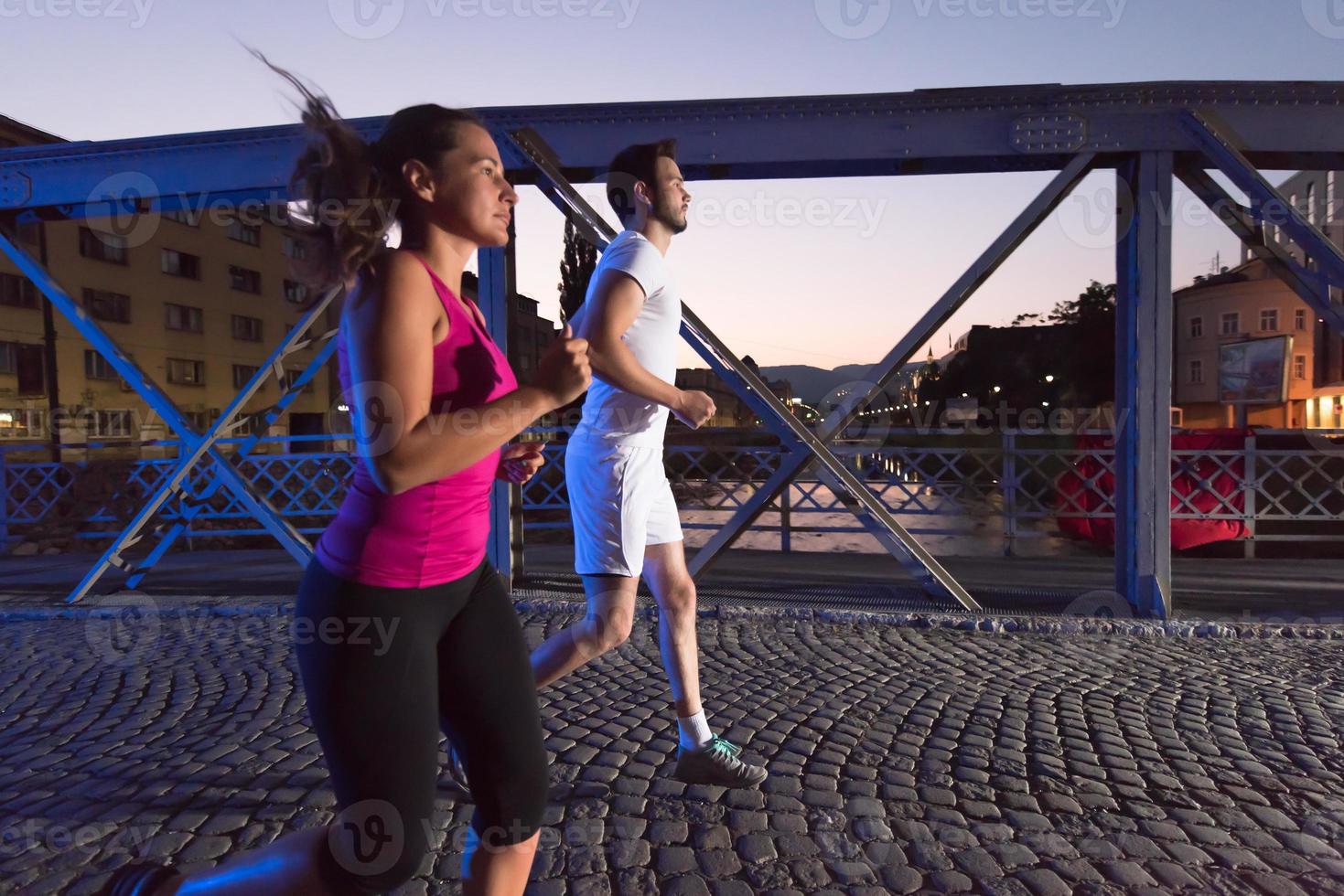 coppia che fa jogging attraverso il ponte della città foto