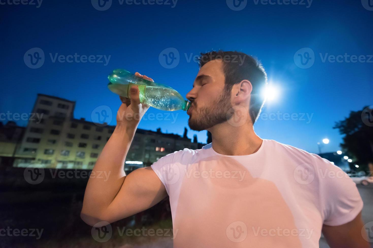 uomo che beve acqua dopo la sessione di corsa foto