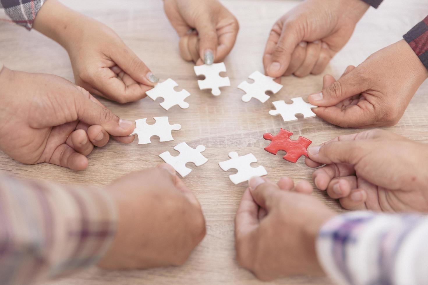 un gruppo di uomini d'affari che assemblano puzzle. il concetto di cooperazione, lavoro di squadra, aiuto e supporto negli affari. partnership di successo aziendale di squadra. foto