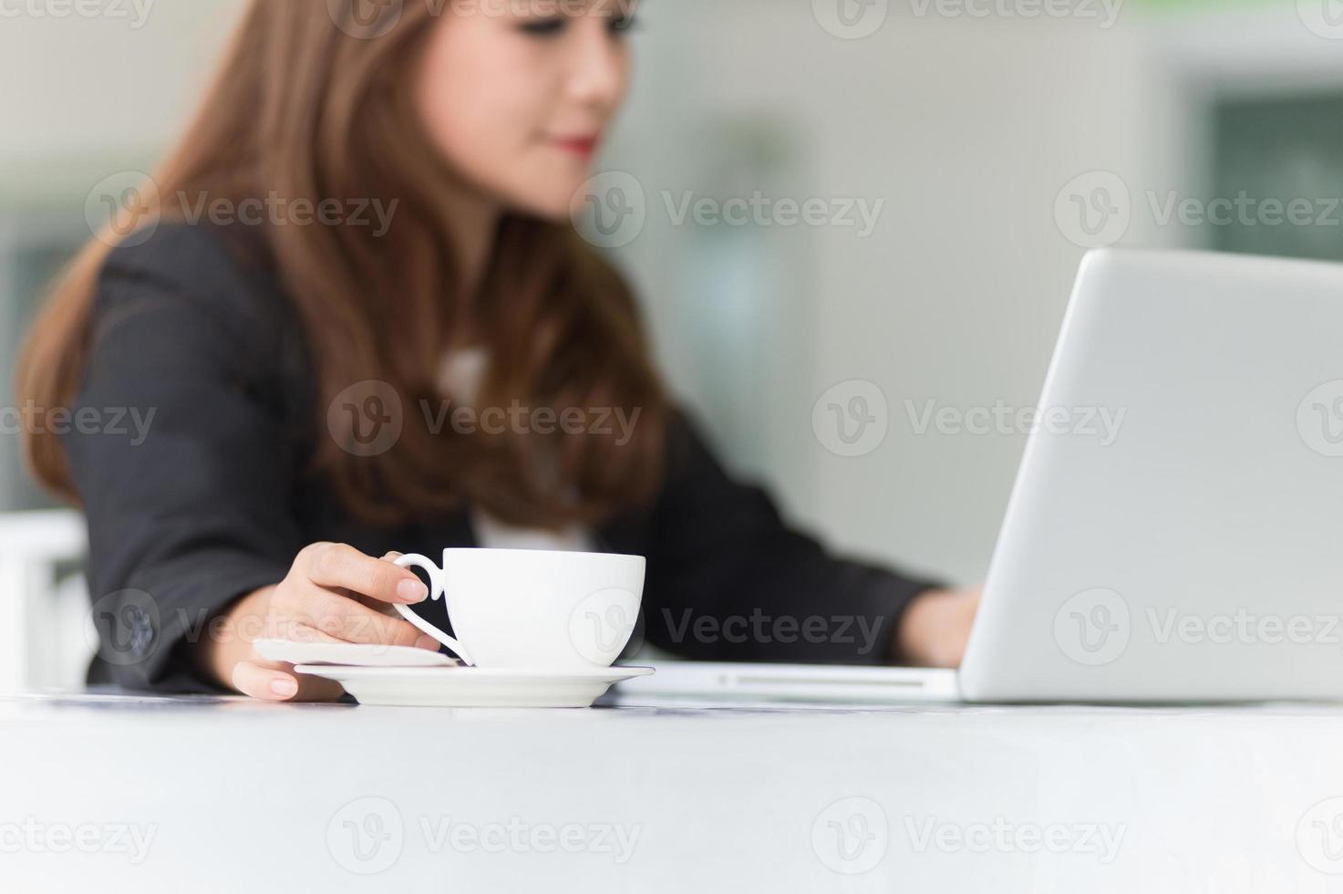 donna dell'Asia in caffè con il computer portatile e caffè, concetto di affari foto