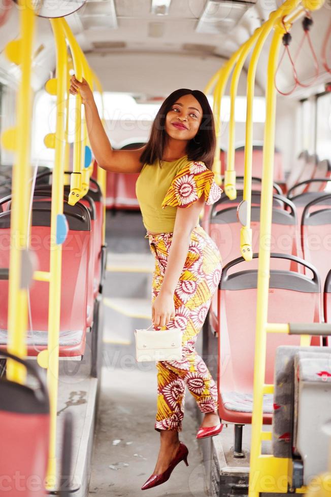 giovane donna afroamericana alla moda che guida su un autobus. foto