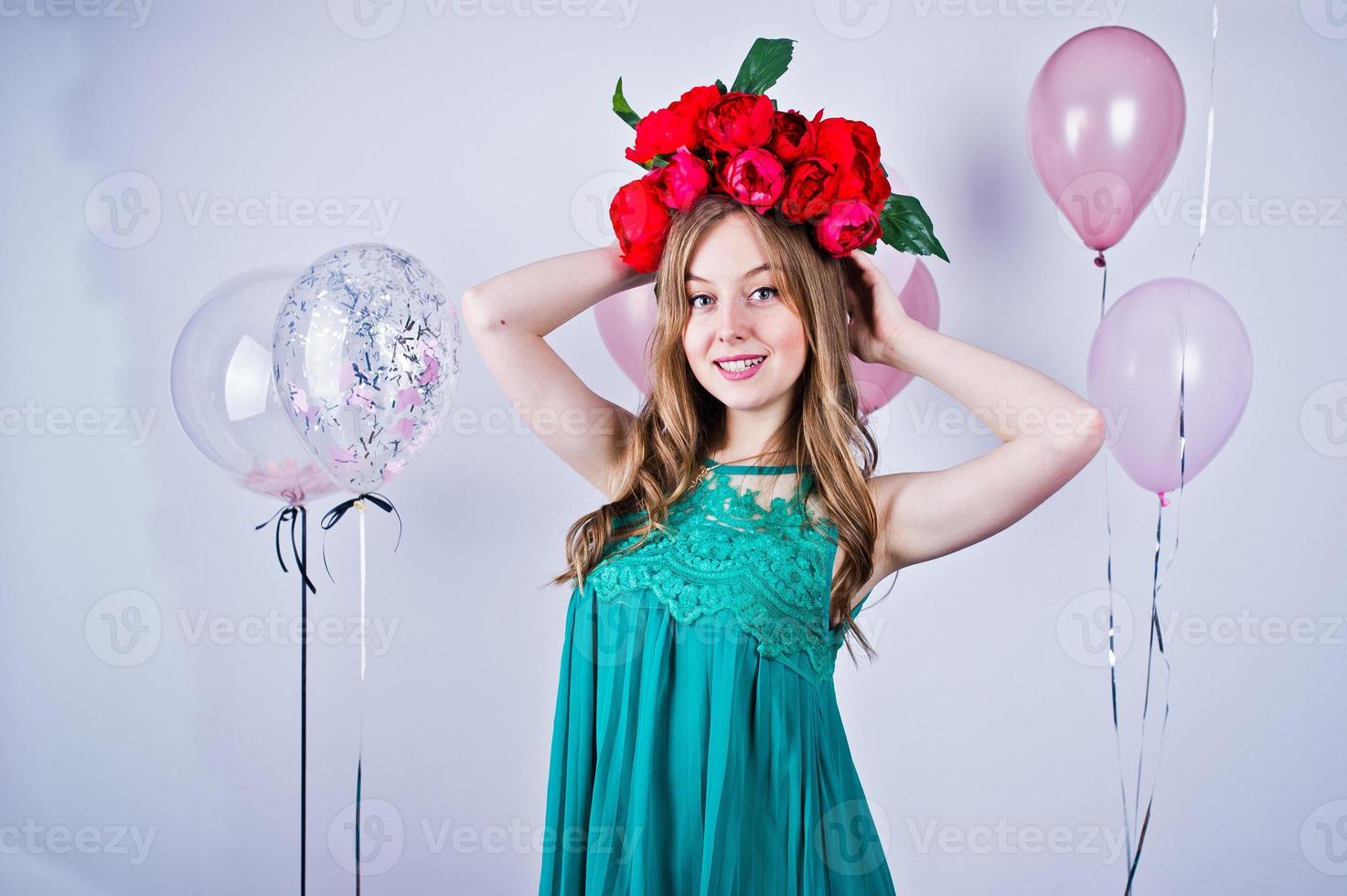 ragazza felice in abito turchese verde e corona con palloncini colorati isolati su bianco. festeggiare il tema del compleanno. foto