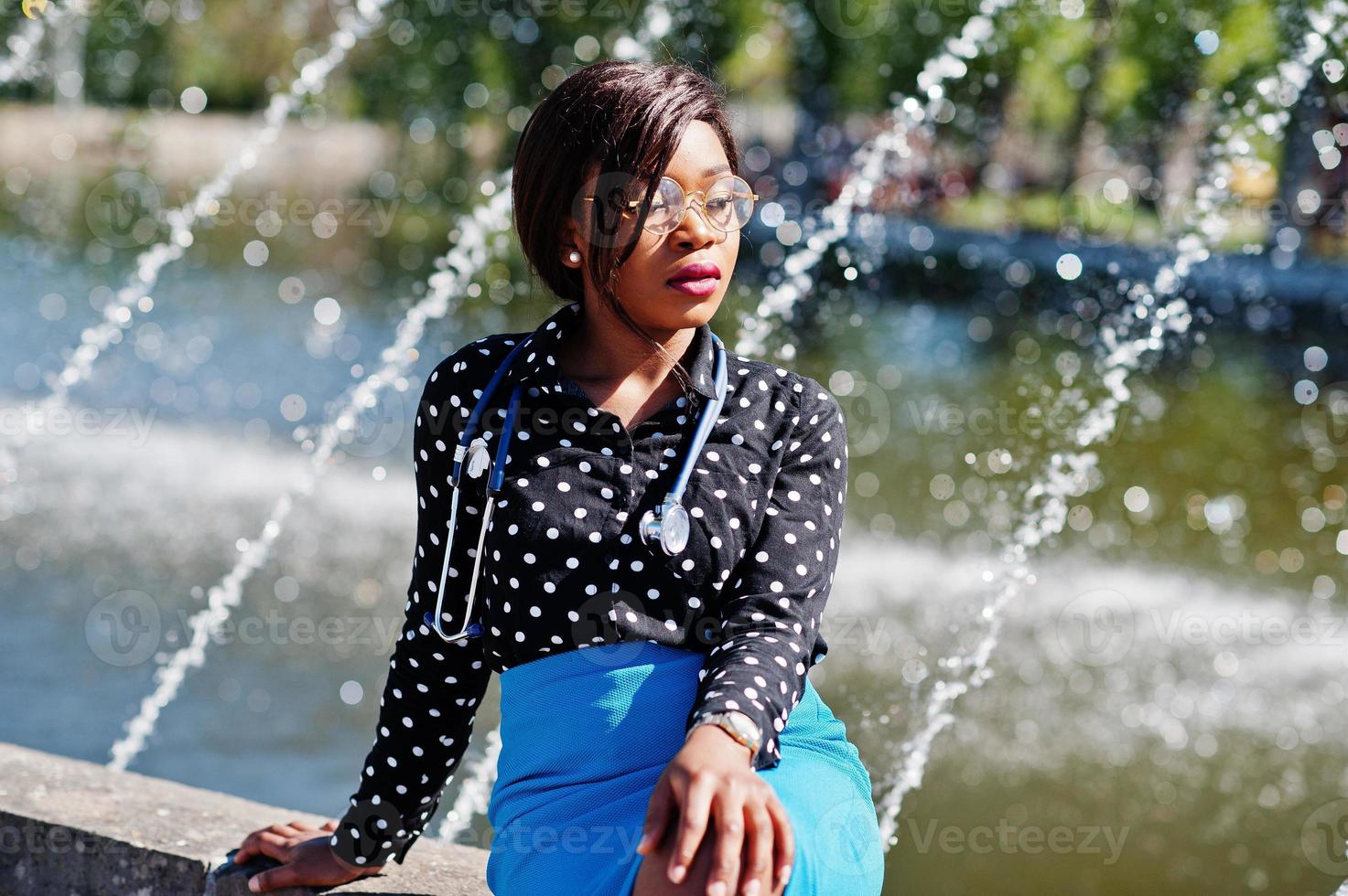 medico afroamericano femmina con stetoscopio poste fontane di sfondo all'aperto. foto