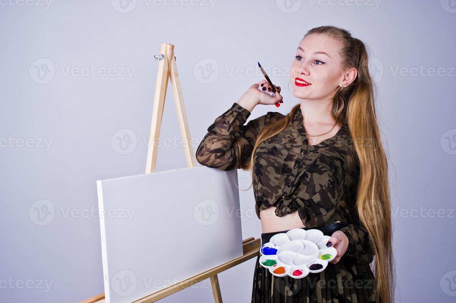 bella donna artista pittore con spazzole e tela a olio in posa in studio isolato su bianco. foto