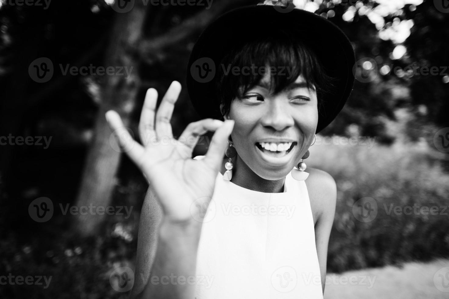 incredibile donna modello afroamericano in pantaloni verdi e cappello nero in posa al parco. foto