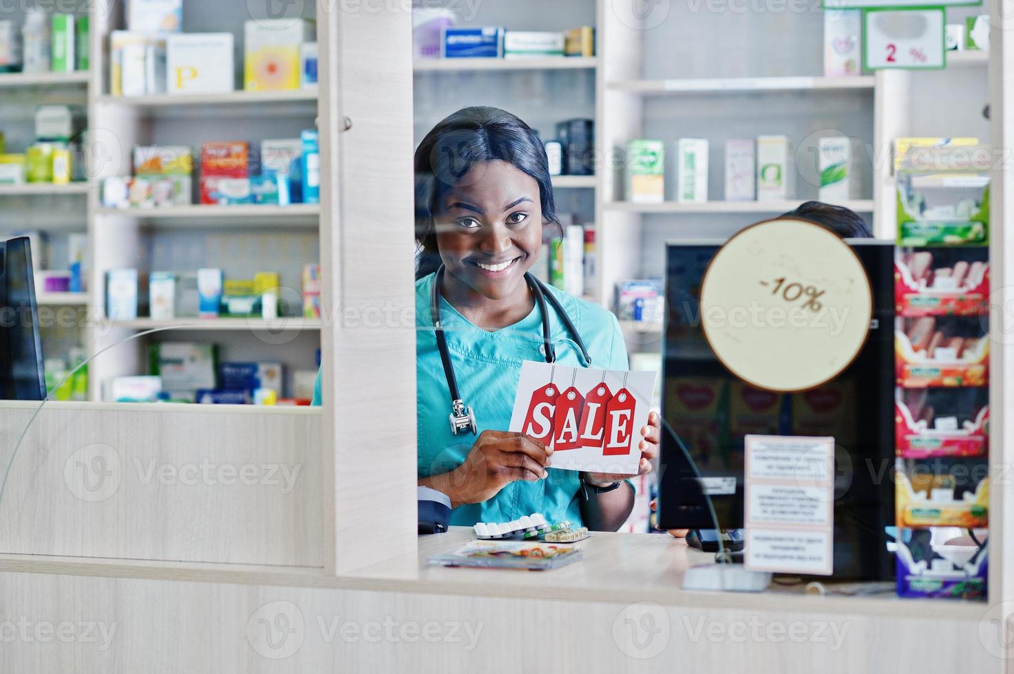 due farmacisti afroamericani che lavorano in farmacia presso la farmacia dell'ospedale. assistenza sanitaria africana. cassiere che detiene la vendita. foto