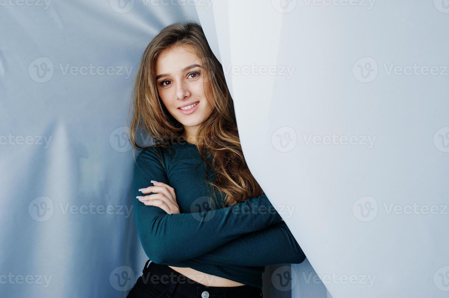 bella ragazza bruna indossa sul verde, in posa alle tende. ritratto del modello in studio. foto