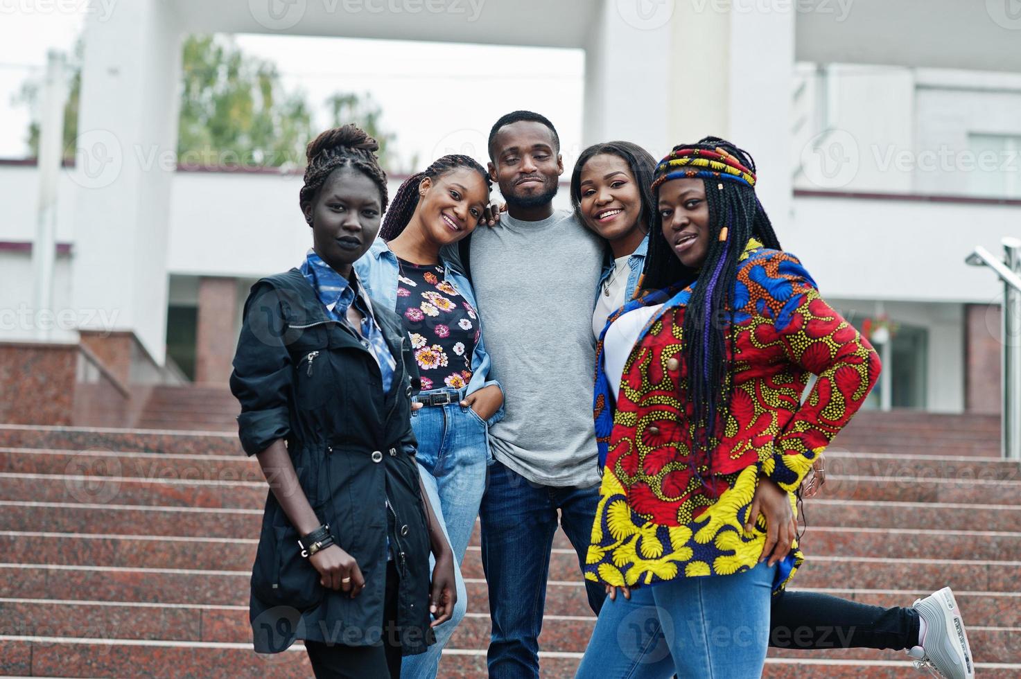 gruppo di cinque studenti universitari africani che trascorrono del tempo insieme nel campus nel cortile dell'università. amici afro neri che studiano. tema dell'educazione. foto