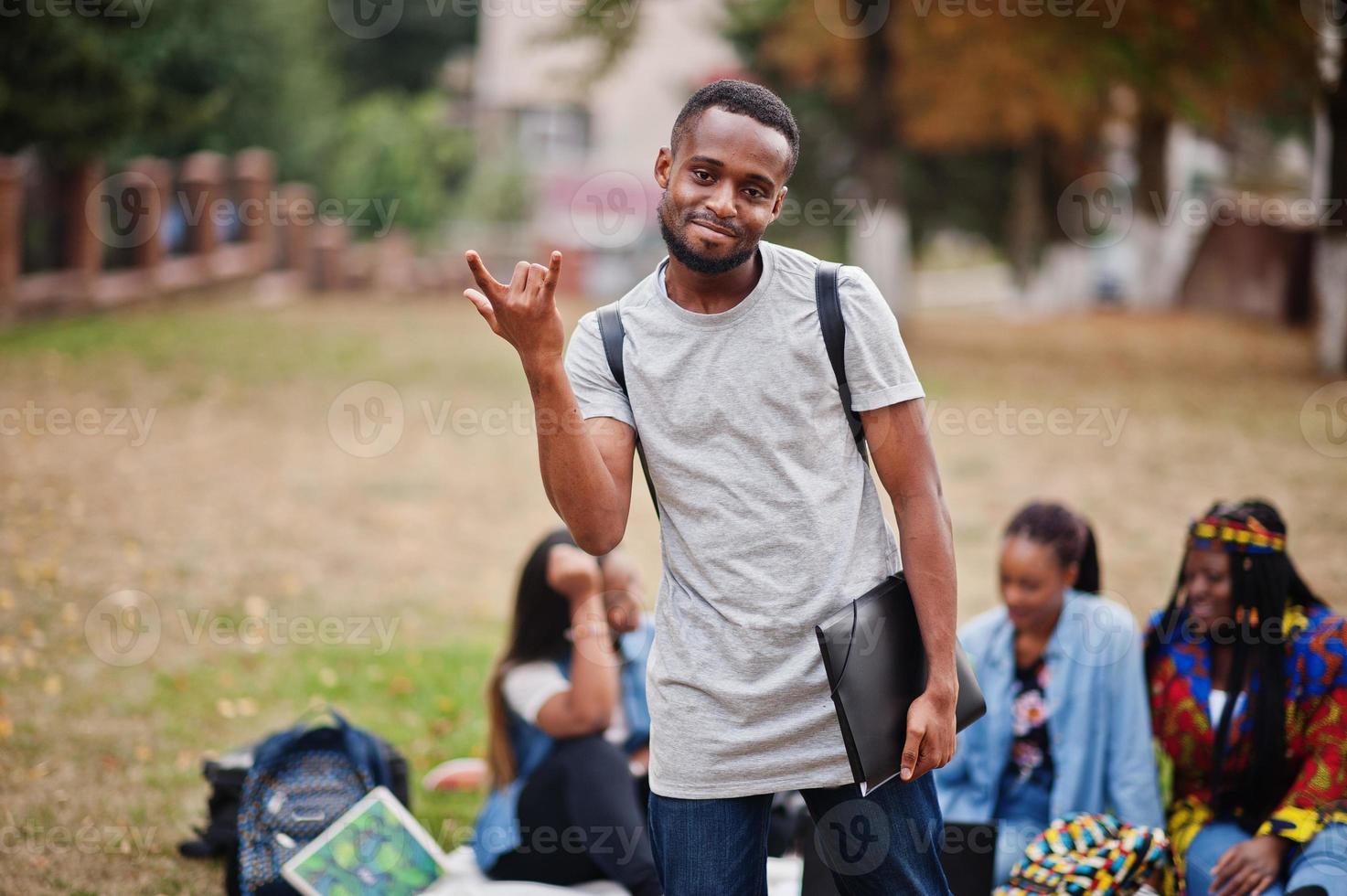 gruppo di cinque studenti universitari africani che trascorrono del tempo insieme nel campus nel cortile dell'università. amici afro neri che studiano. tema dell'educazione. foto