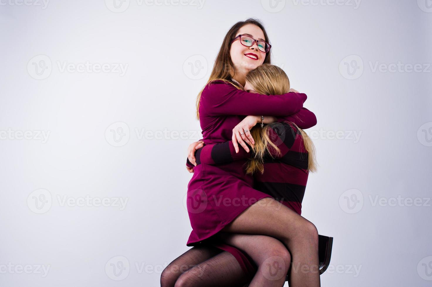 ragazze in abiti viola che si divertono e posano sulla sedia in studio. foto