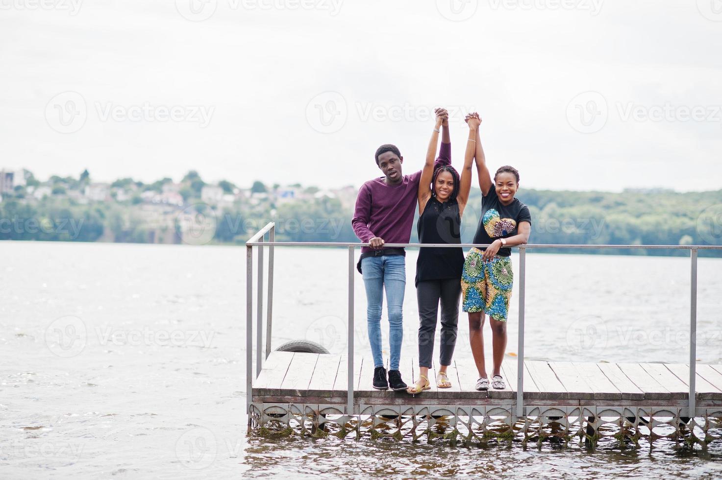 tre amici afroamericani posati sul molo. foto