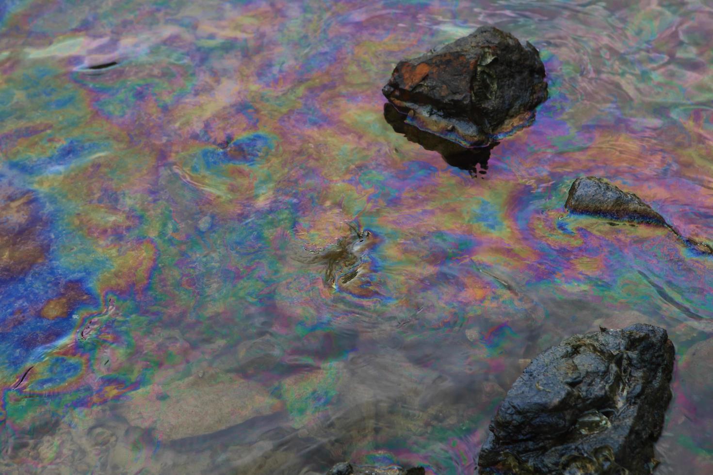 petrolio greggio in acqua di mare e riflesso arcobaleno foto