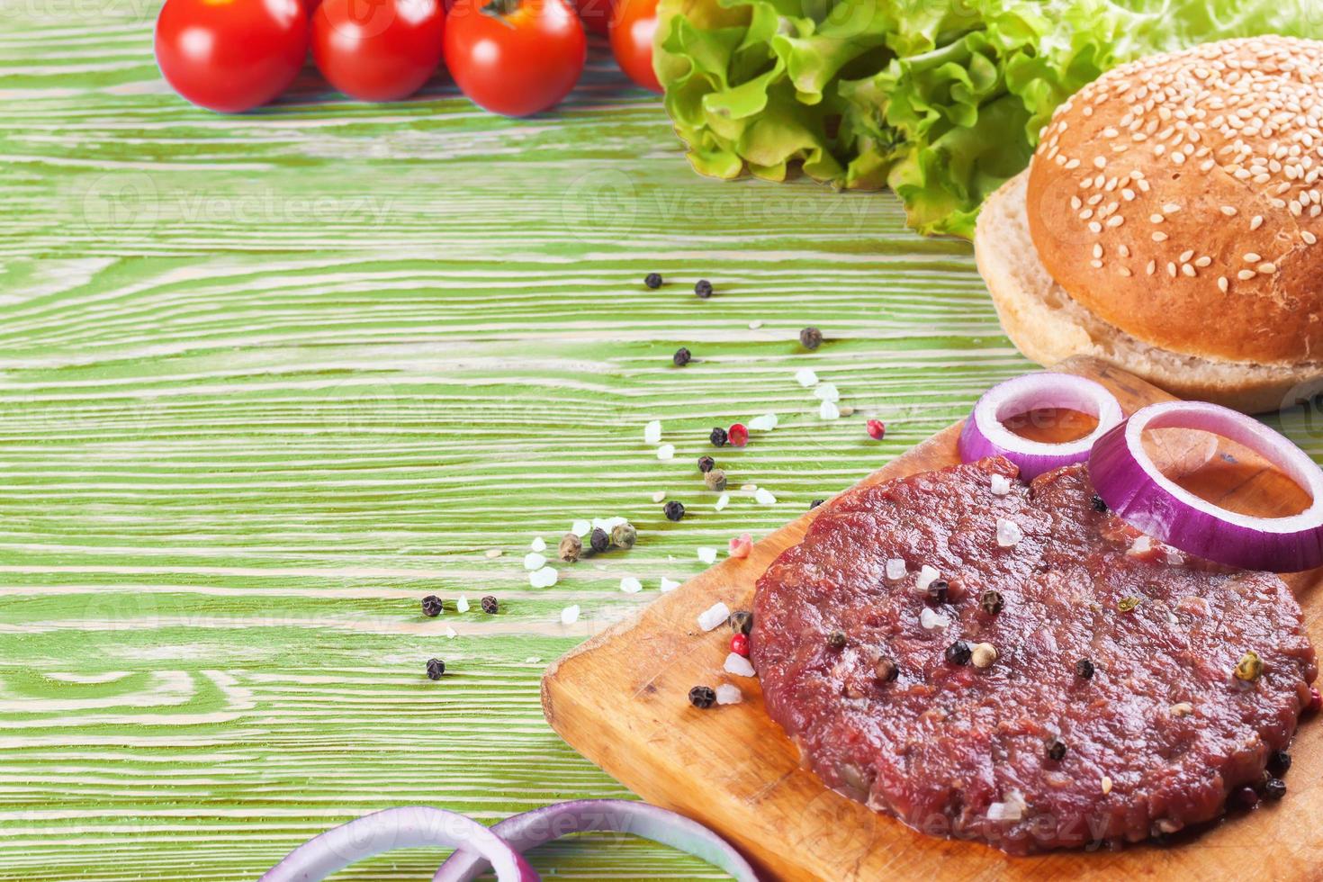 gli ingredienti per l'hamburger su fondo di legno verde foto