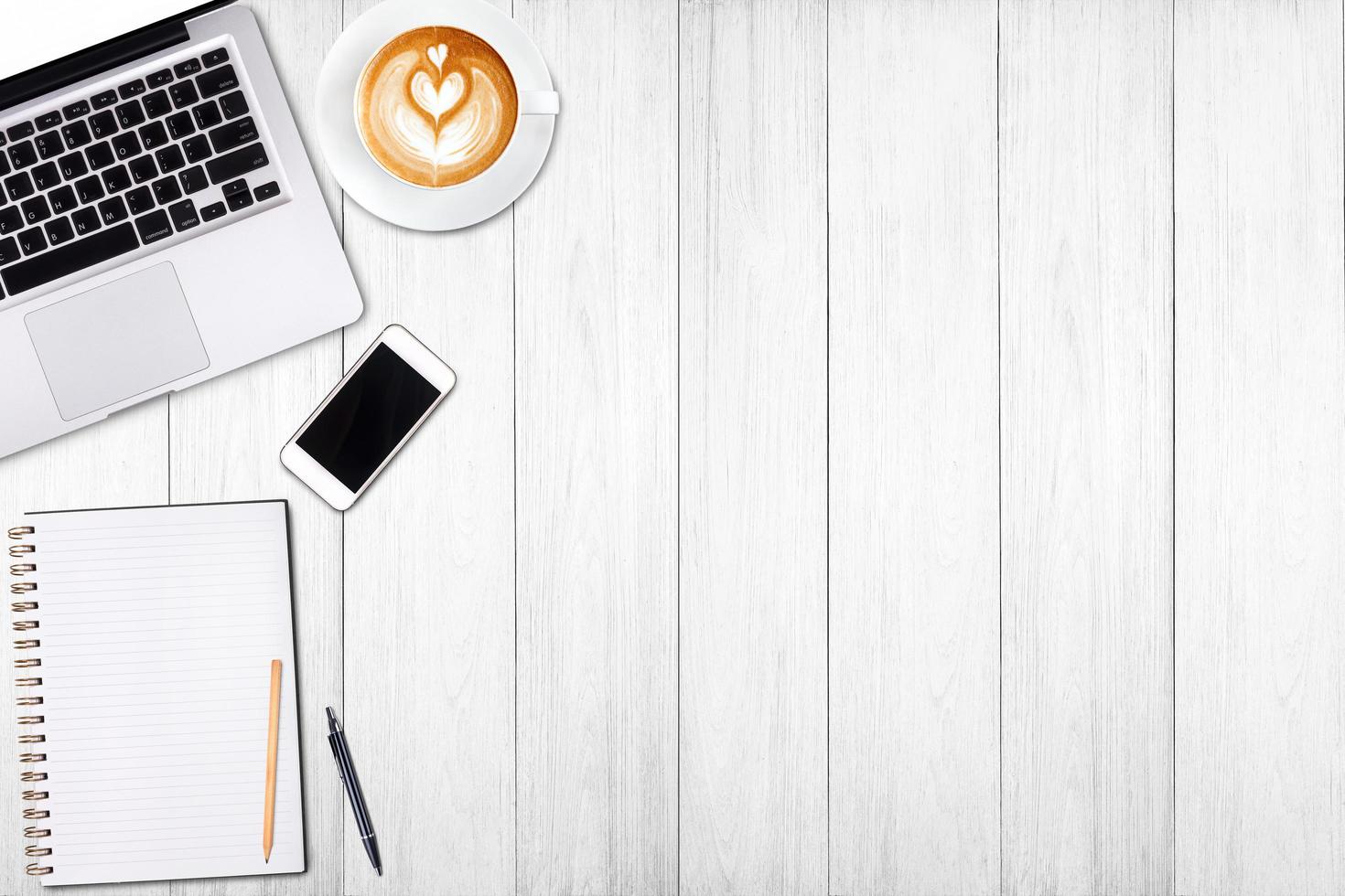 computer portatile o notebook con vista dall'alto, telefono cellulare e tazza di caffè latte art su tavola di legno. modello di business mock up per aggiungere il tuo testo. foto