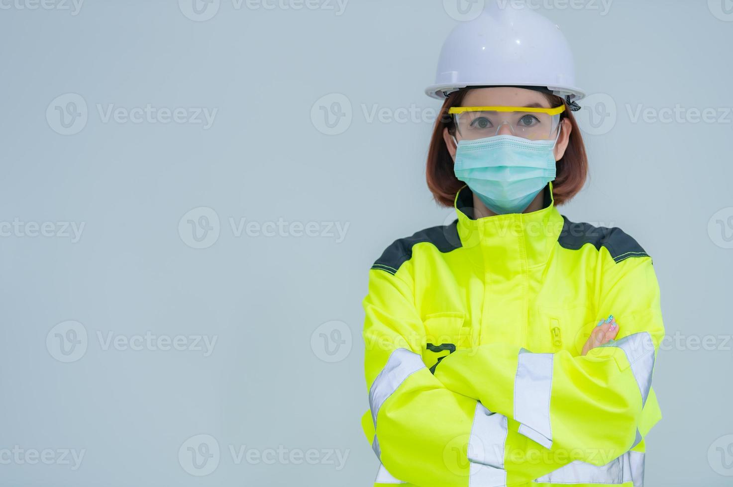la bella donna asiatica dell'ingegnere indossa un vestito, occhiali e indossa un casco su sfondo bianco, la gente della Tailandia foto