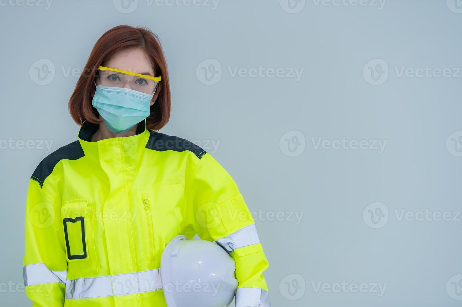 la bella donna asiatica dell'ingegnere indossa un vestito, occhiali e indossa un casco su sfondo bianco, la gente della Tailandia foto