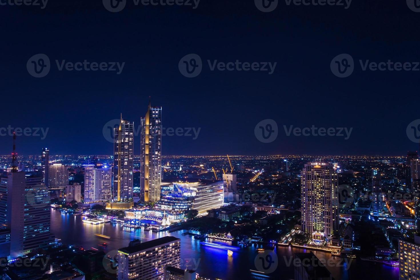 gli edifici del centro città lungo il fiume Chao Phraya, Bangkok di notte, lungo il fiume hanno molti hotel e edifici alti per affari. Bangkok è il centro per gli investimenti. una delle città colorate in Asia. foto