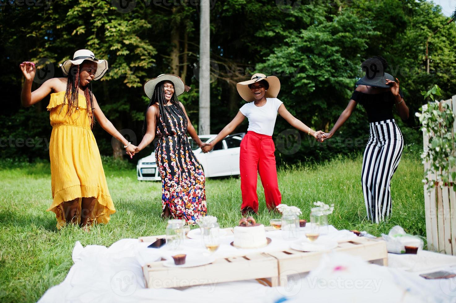gruppo di ragazze afroamericane che celebrano la festa di compleanno divertendosi e ballando all'aperto con decorazioni. foto