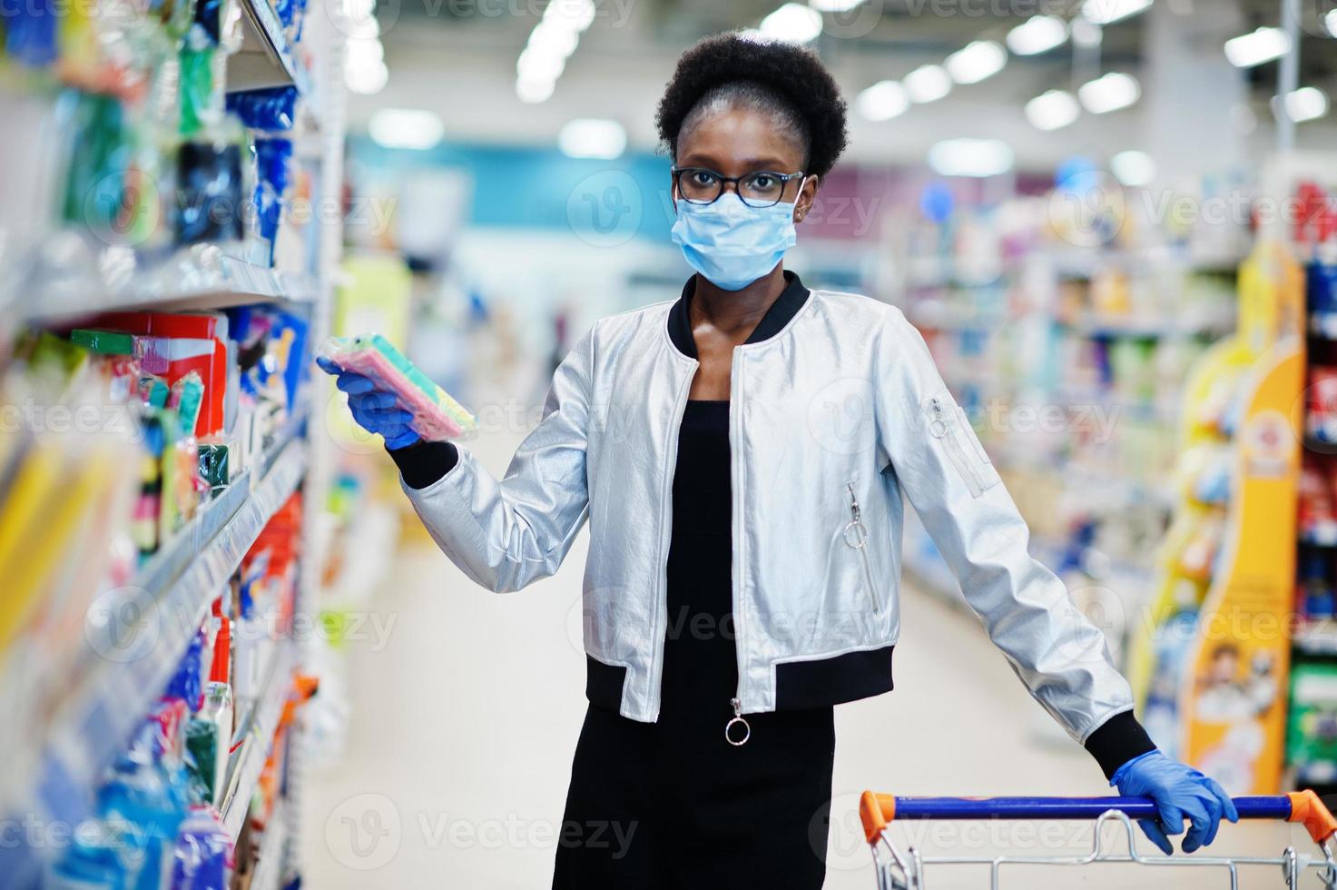 donna africana che indossa maschera medica monouso e guanti che acquistano al supermercato durante l'epidemia di pandemia di coronavirus. tempo epidemico. foto