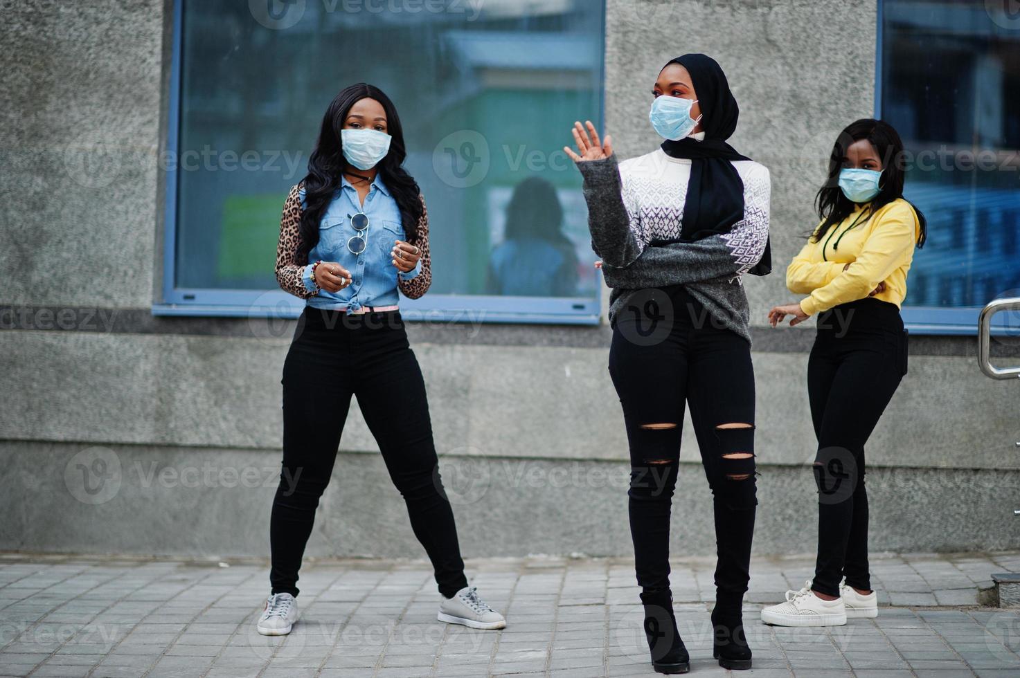 gruppo di tre giovani volontari afroamericani che indossano una maschera per il viso all'aperto. quarantena del coronavirus e pandemia globale. foto