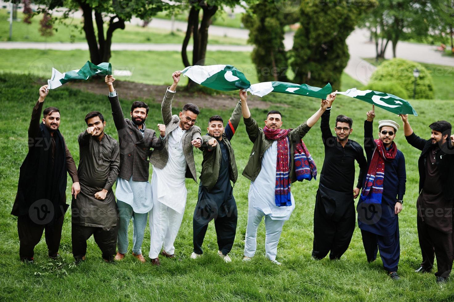 gruppo di pakistani che indossano abiti tradizionali salwar kameez o kurta con bandiere pakistane. foto