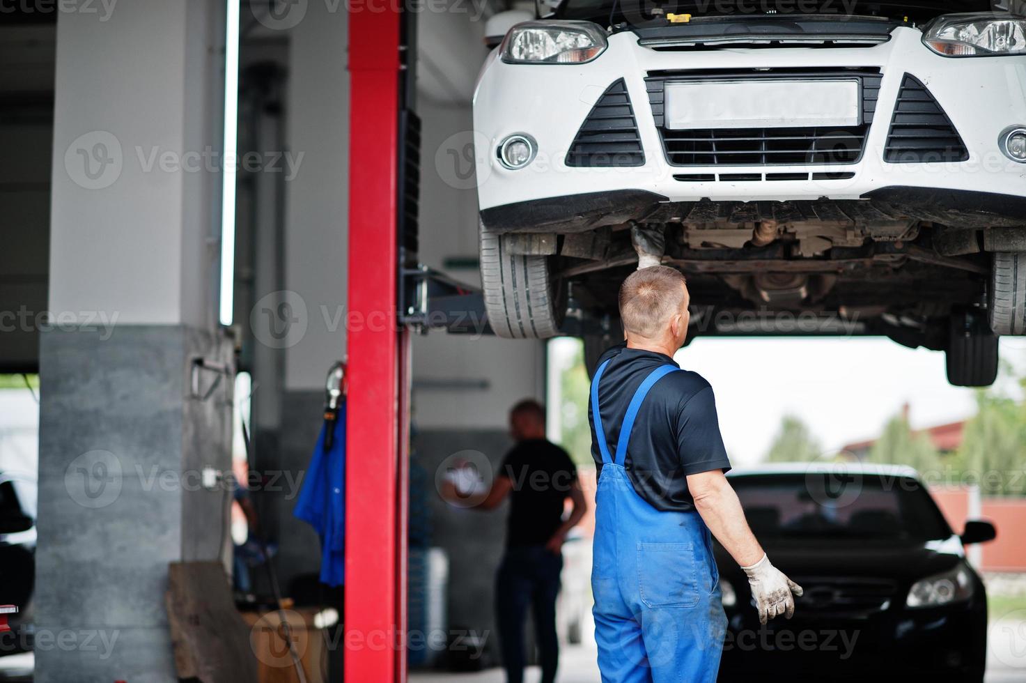 tema riparazione e manutenzione auto. meccanico in uniforme che lavora in servizio auto. foto