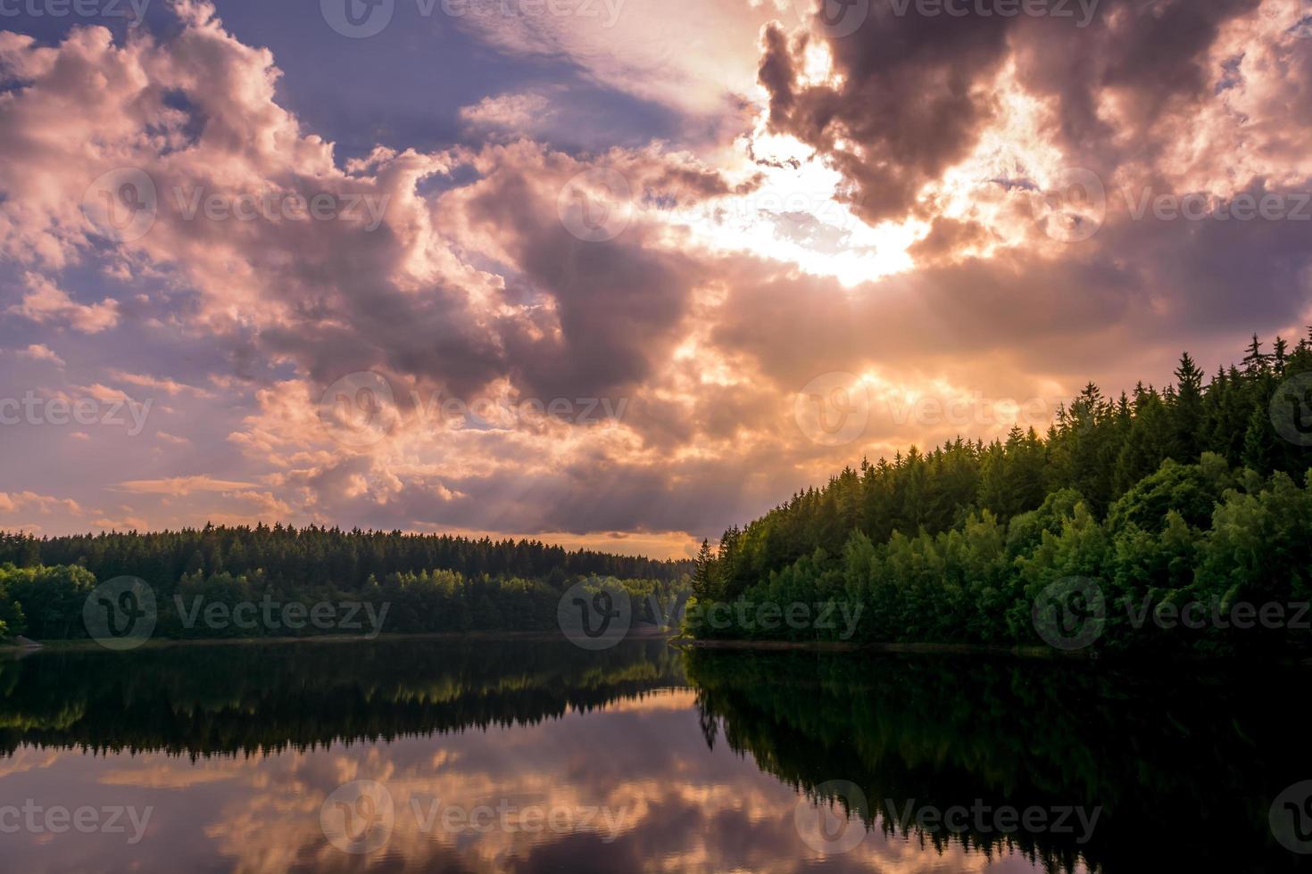 tramonto viola colorato su un tranquillo lago rurale foto