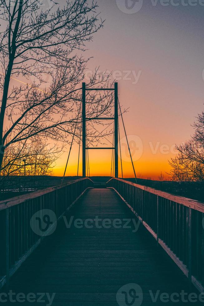 Inquadratura dal basso di un ponte stagliato al tramonto foto