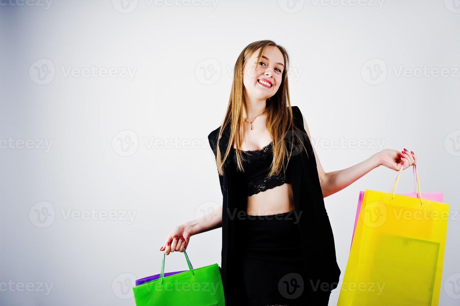 modello ragazza in abbigliamento nero con borse della spesa colorate poste in studio su sfondo bianco. foto