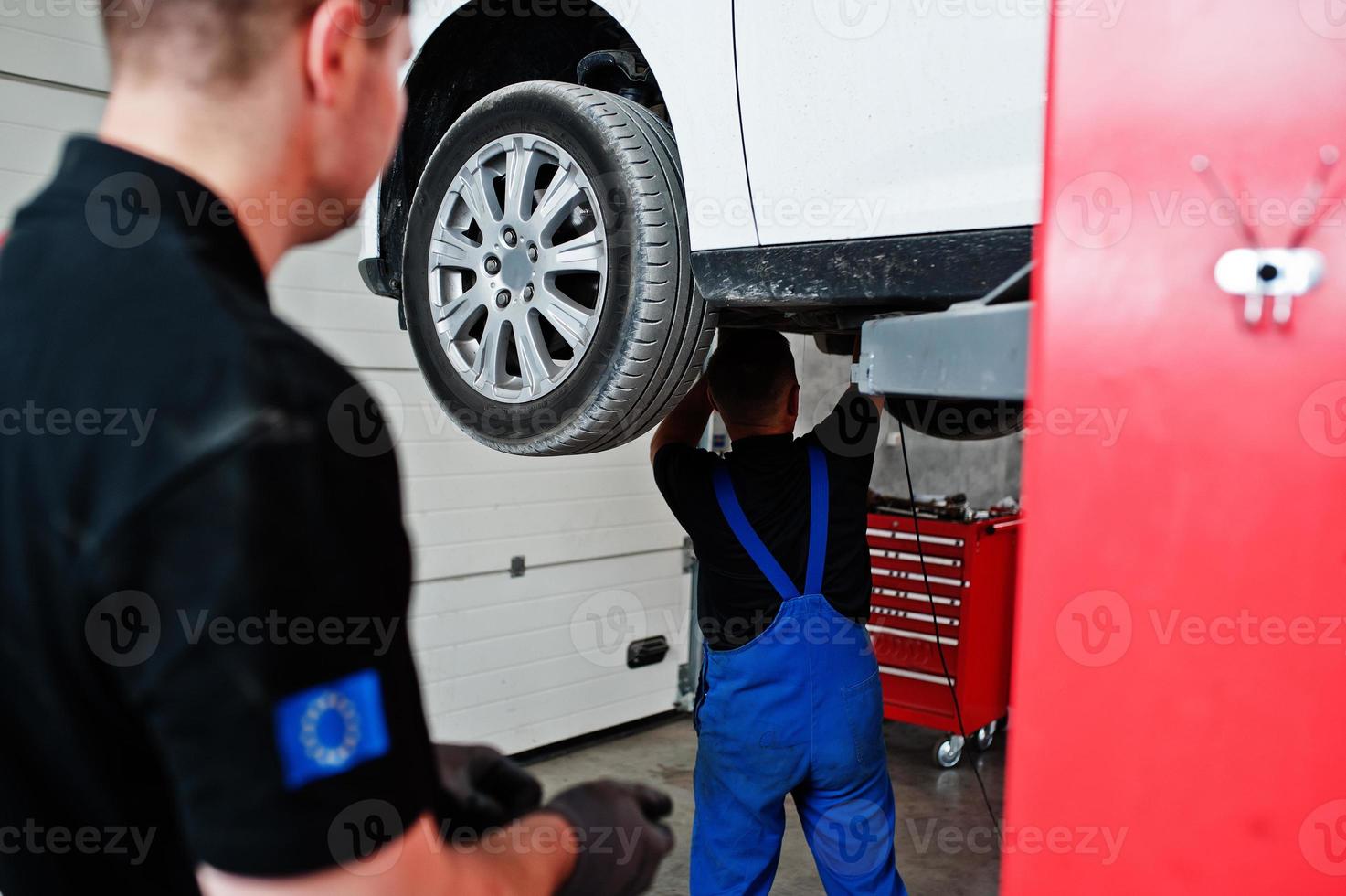 tema riparazione e manutenzione auto. due meccanici in divisa che lavorano in servizio auto. foto