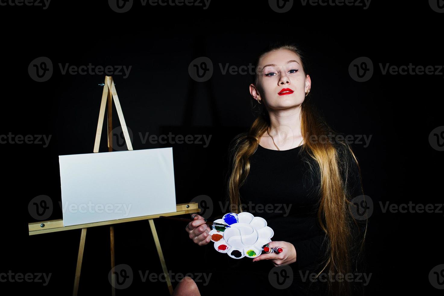 bella donna artista pittore con spazzole e tela ad olio in posa in studio isolato su nero. foto