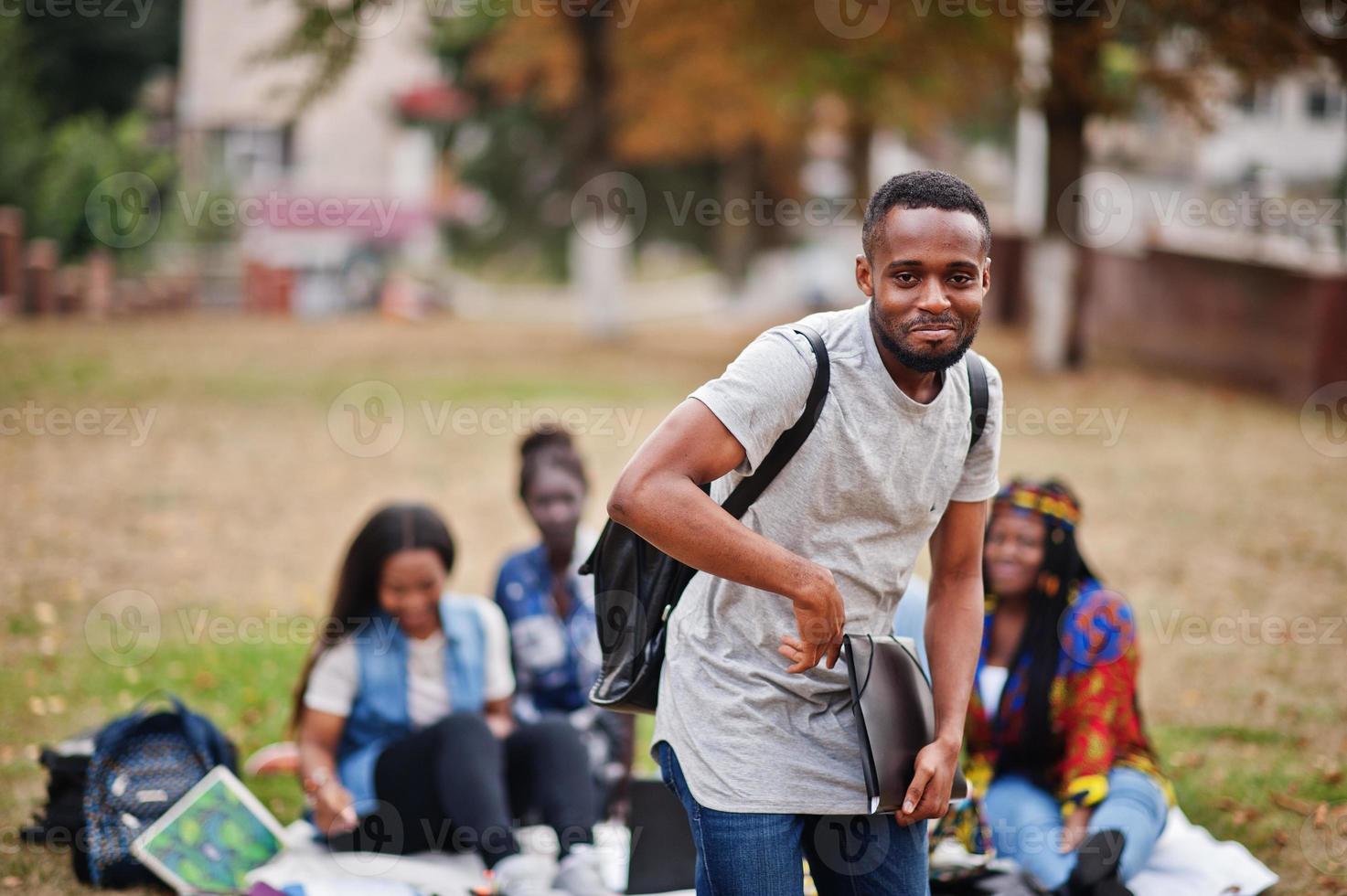 gruppo di cinque studenti universitari africani che trascorrono del tempo insieme nel campus nel cortile dell'università. amici afro neri che studiano. tema dell'educazione. foto