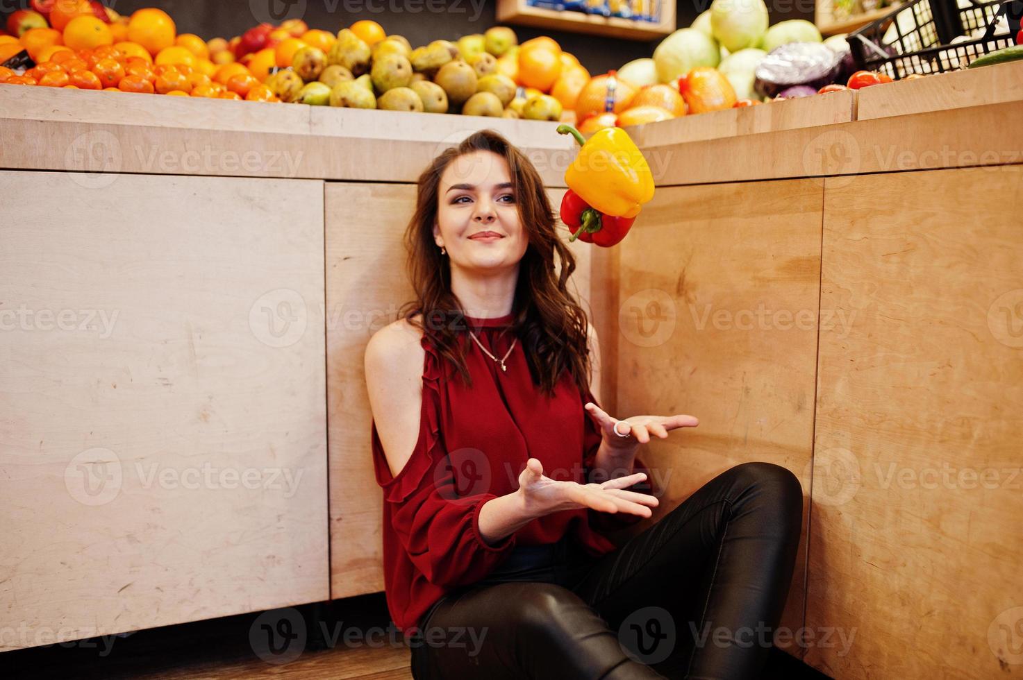 ragazza in peperoni rossi sul negozio di frutta. foto