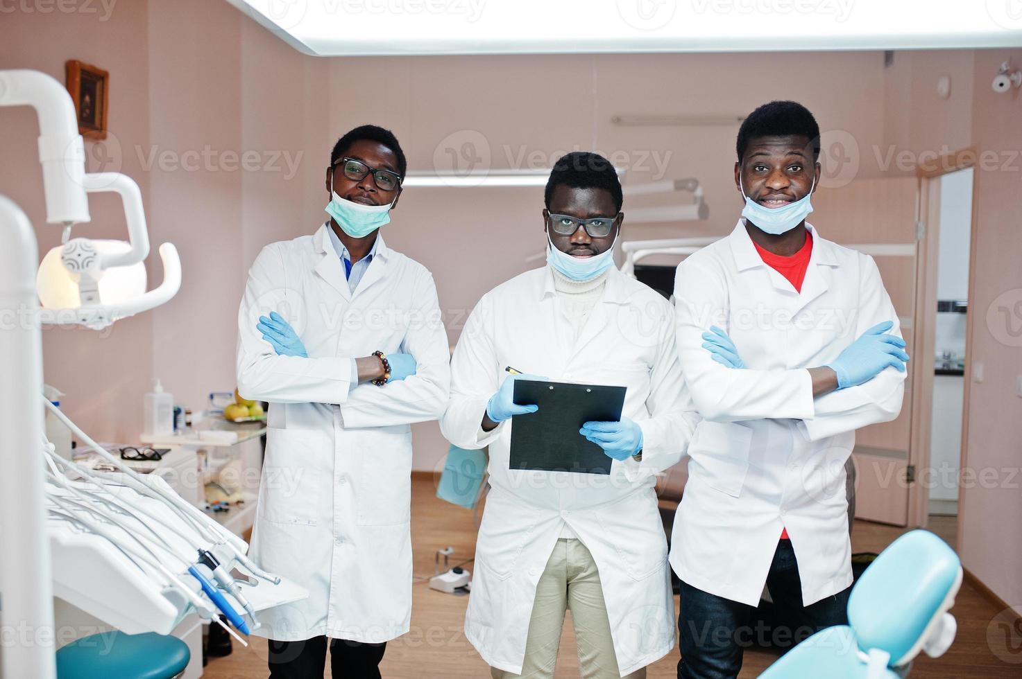 tre medici maschi afroamericani che lavorano, in posa con i colleghi in clinica odontoiatrica. foto