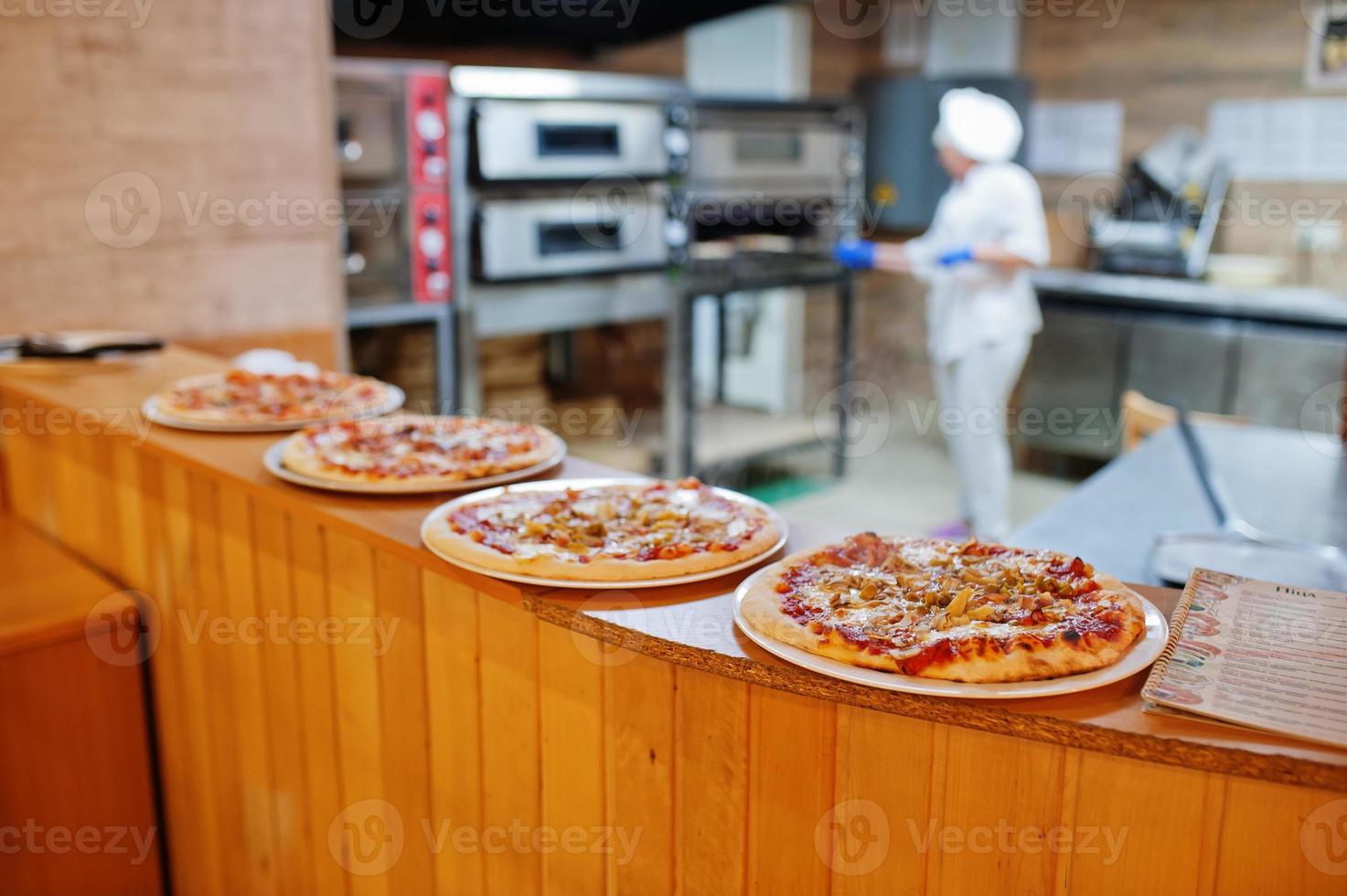 chef femminile che prepara pizza nella cucina del ristorante. foto