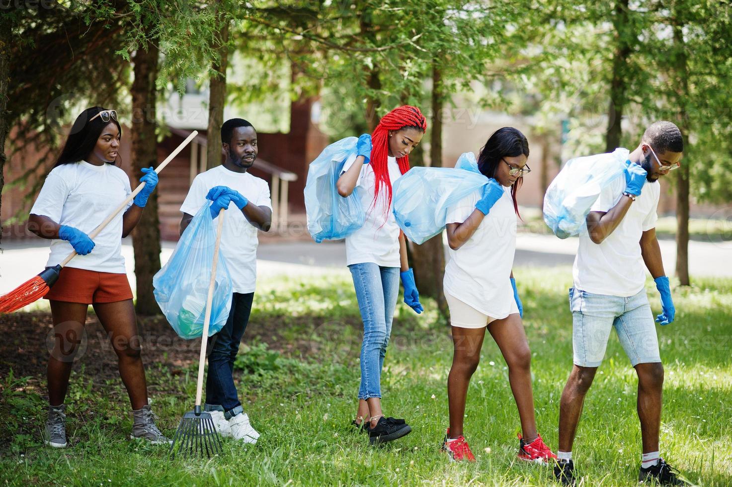 gruppo di volontari africani felici con l'area di pulizia dei sacchi della spazzatura nel parco. concetto di volontariato, carità, persone ed ecologia in africa. foto