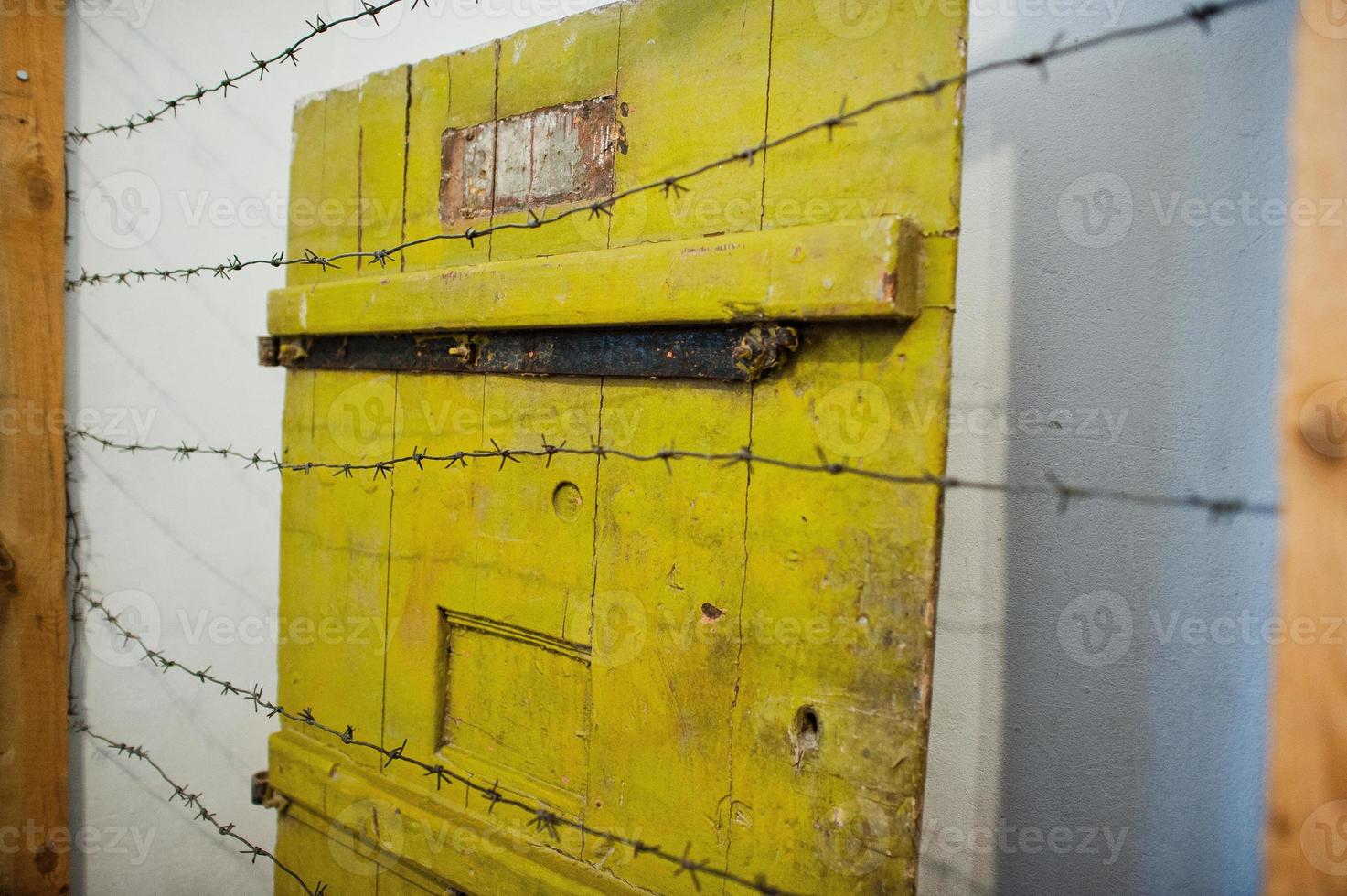 porte gialle della prigione dietro il filo spinato. foto
