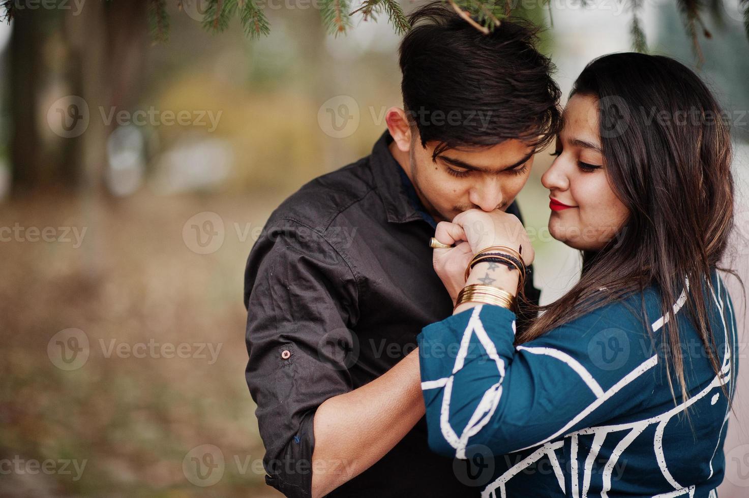 storia d'amore di una coppia indiana in posa all'aperto, l'uomo le bacia la mano. foto