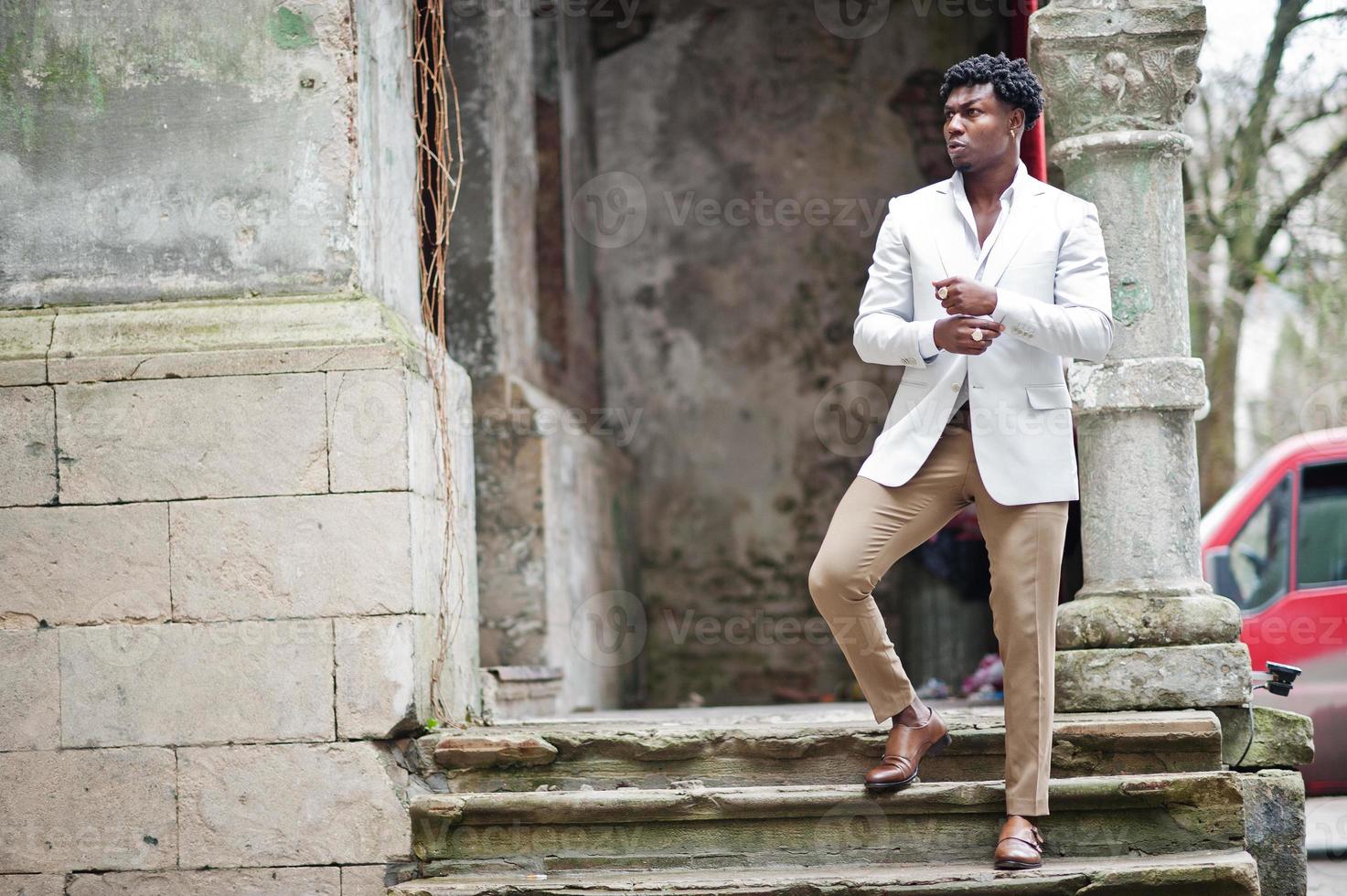 premuroso giovane gentiluomo afroamericano bello in abiti da cerimonia. uomo nero elegante modello in giacca bianca. foto